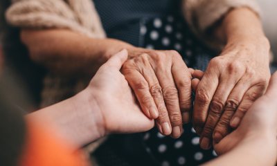 Hands of an older and younger person clasping