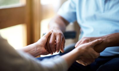 Two people hold hands while sitting