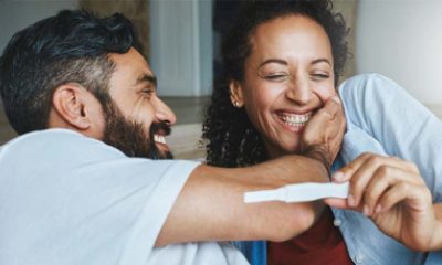 A couple smiles while looking at results on an instant pregnancy test