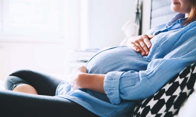 Pregnant woman holds her belly and smiles