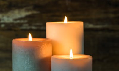 Three lit white candles providing ambient light