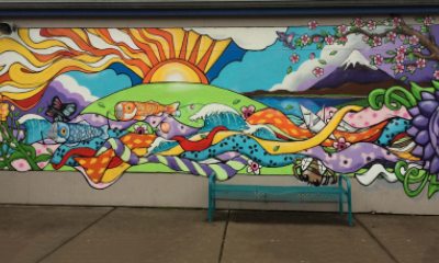 Colorful mural with animals and other scenes of nature on the wall of a school
