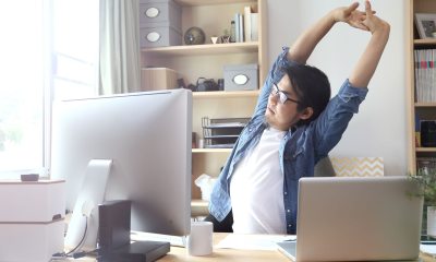 A man stretching at his work desk