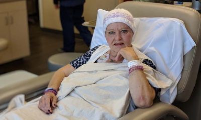 A woman looks at the camera from a patient bed