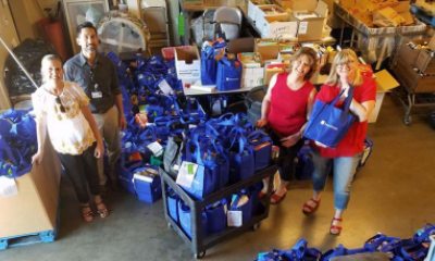 A group of volunteers stop filling donation bags to smile for the camera