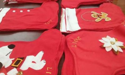Red holiday stockings adorned with Christmas themed decorations and the year 2017 stitched in the sides