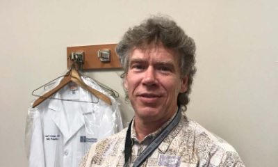 Candid photo of Timothy Randall with doctor's jacket hanging in the background