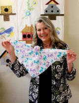 Jill Day holds up a "lovey doll" for NICU families