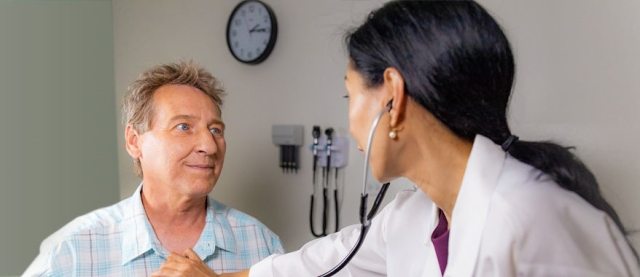 A PeaceHealth cardiology provider examines a patient in a clinical setting.
