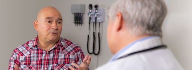 A PeaceHealth provider discusses the TAVR procedure with a patient in a clinical setting