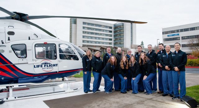 The Southwest Medical Center Trauma team stands on the helipad next to a helicopter