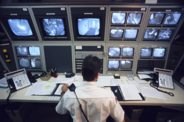 Security officer sits at desk with video monitors
