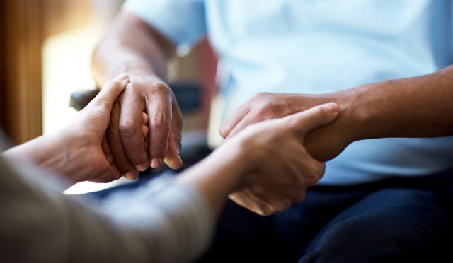 Caregiver holding patient hands