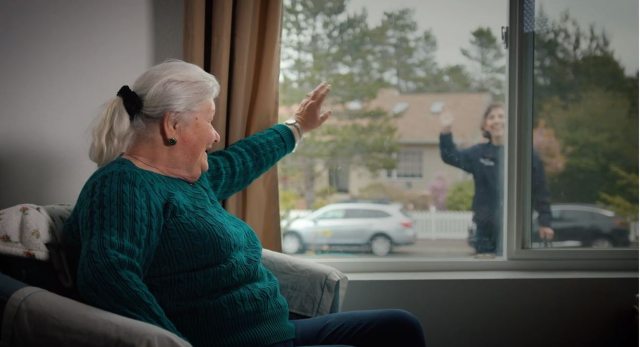 Maggie Donathan waves through her window to Wendy Sullivan