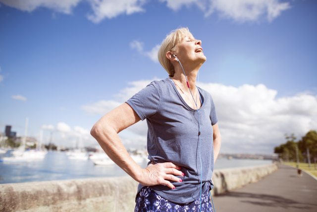 Woman standing outside rests during exercise