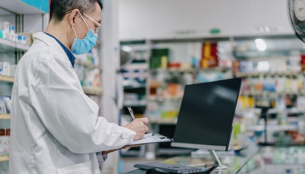 Pharmacy tech writes on clipboard