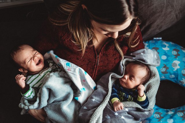 Mother holds twin babies
