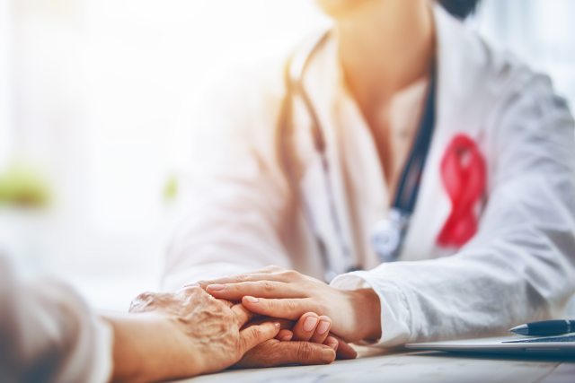 Care provider reaches for hands of woman to provide comfort