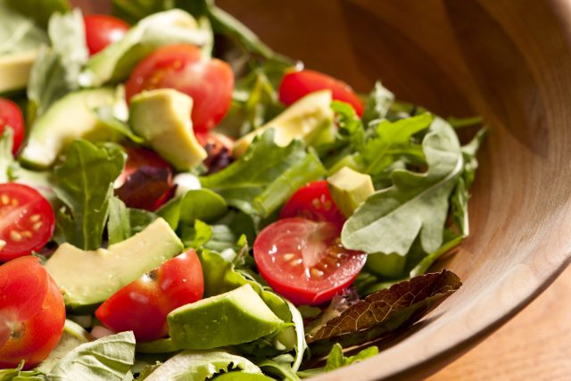 Bowl of lettuce, cherry tomato and avocado chunks