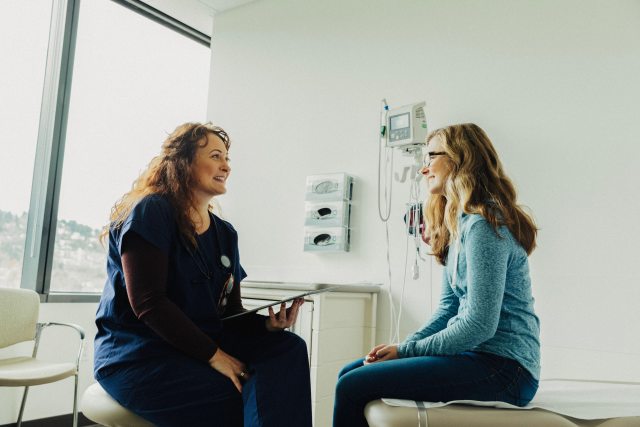 Patient sits on exam table and talks to provider