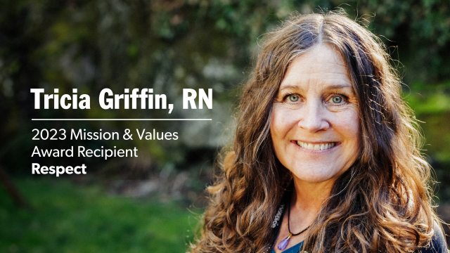 Tricia Griffin outside in front of green trees and grass