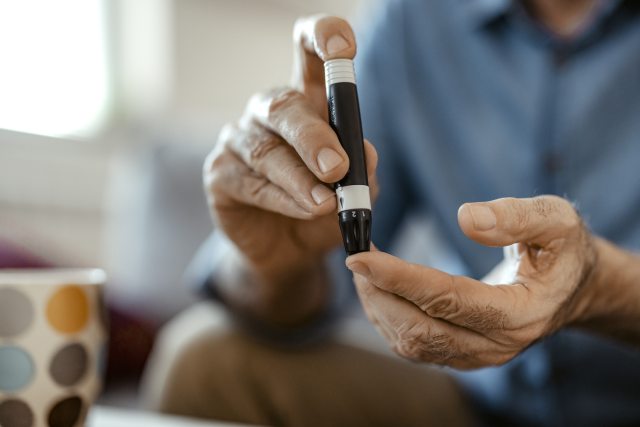 Man using diabetes finger test.