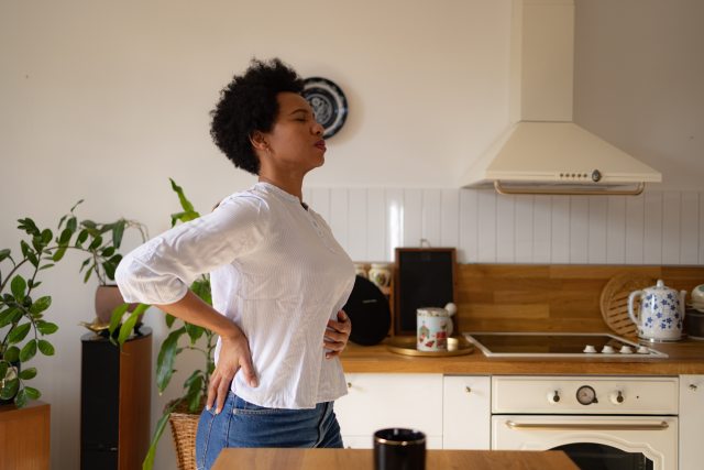 Woman holding her belly from stomach pain.