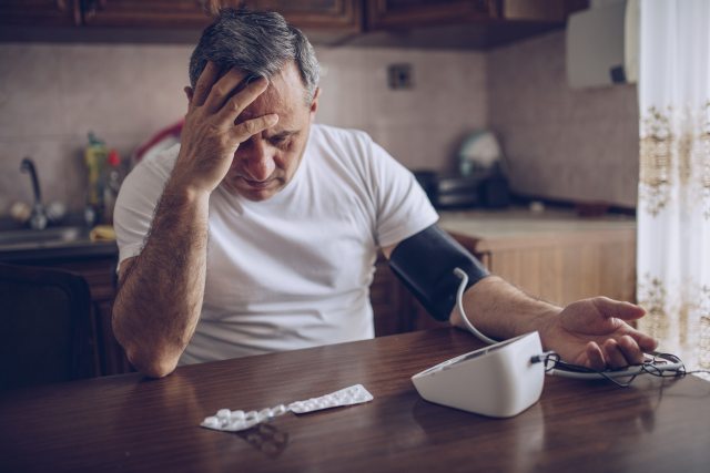 Man taking his blood pressure with an at home test.