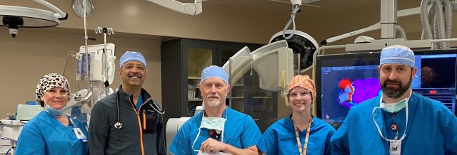 Medical staff stand in an operating room.