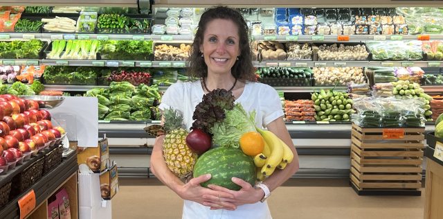 Cecelia Jacobson holds a bounty of fruits and vegetables during a shopping trip at Market of Choice