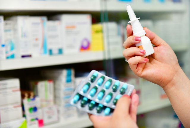 Close-up of hands holding medications at pharmacy