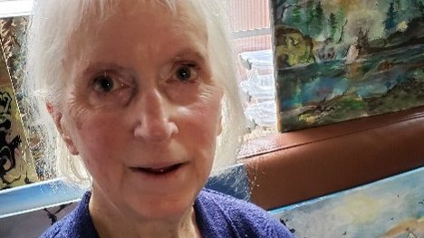 Sherry McCalden in front of some of her paintings