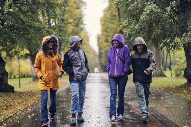 Four adults walking in the rain.