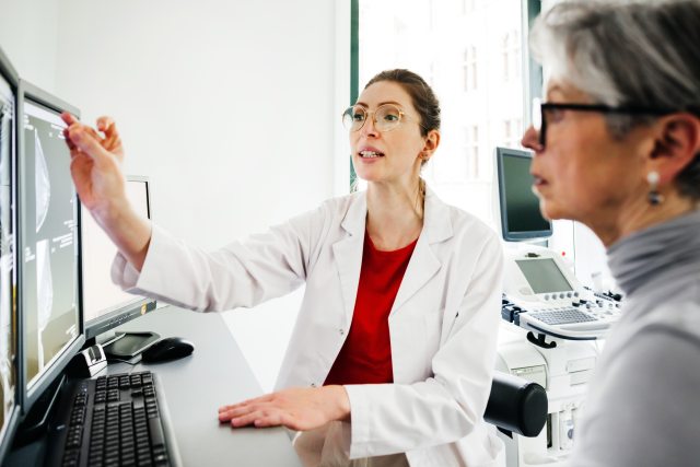 breast surgeon explains mammogram image to patient