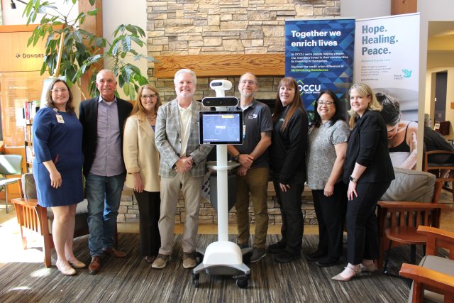 Members of the OCCU Foundation and PeaceHealth Foundation stand aside a computer-like device used by doctors who are offsite to communicate and examine patients.