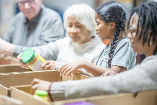 Volunteers pack boxes of supplies at a food bank