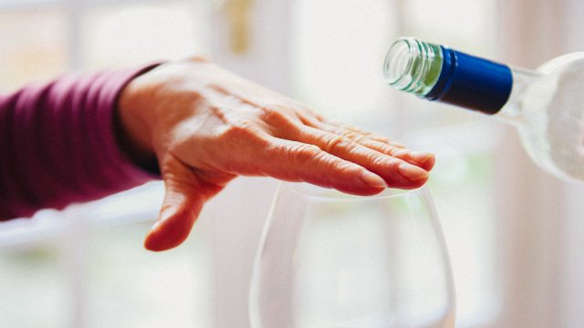 closeup of hand covering top of wine glass