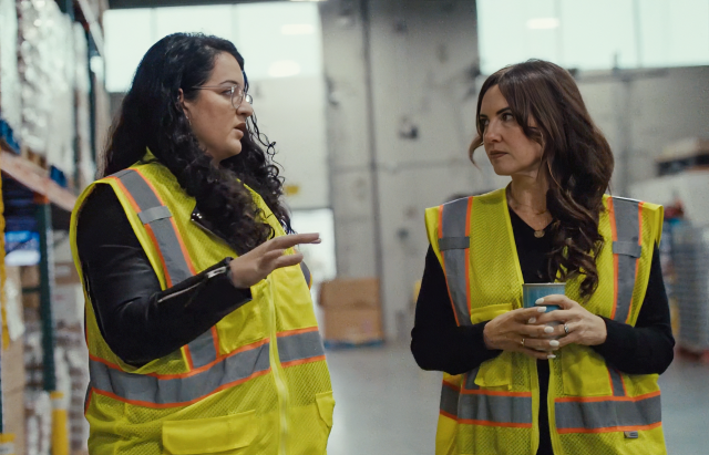 Two women in construction vests in a discussion