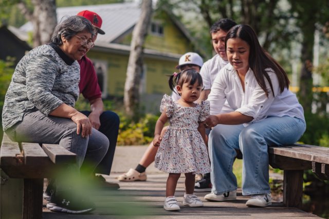 A multigenerational family enjoys time together in a park-like setting