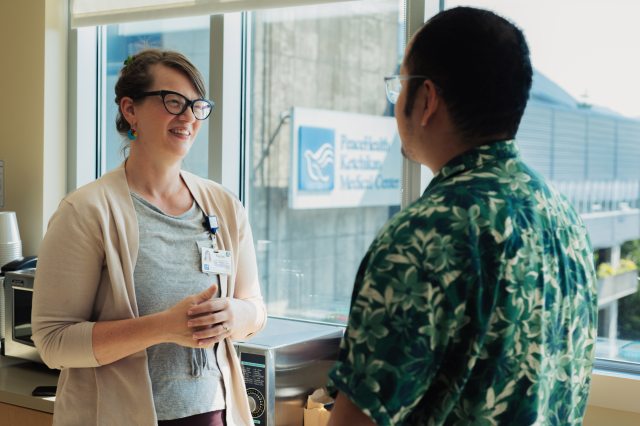 A PeaceHealth caregiver speaks with a patient in a clinical setting