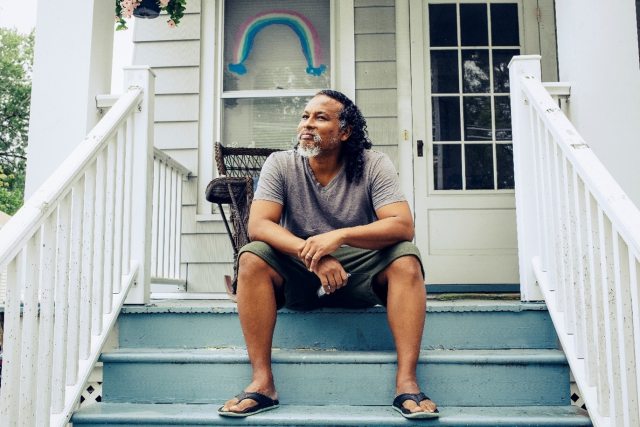 Man sitting outside on porch looking off camera