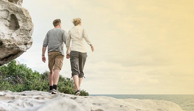 An older couple walking on the beach