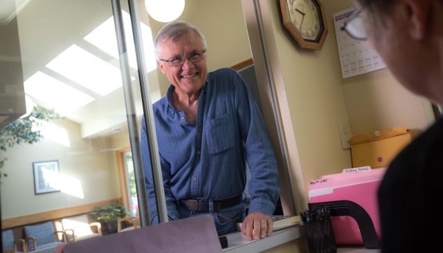 An elderly man checks in for a patient appointment