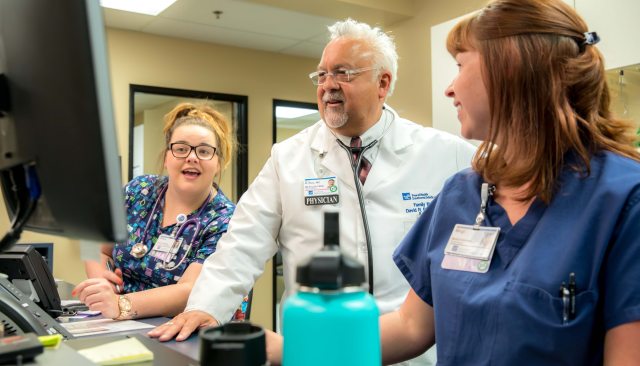 Dr. Ruiz and staff talking while looking at a computer monitor