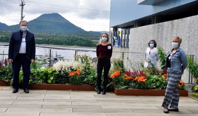 A group of masked caregivers stand 6 feet apart and pose 