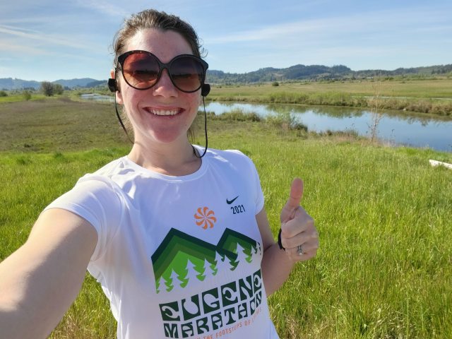 Brittany Reeves smiles and holds a thumbs up while outside for a jog