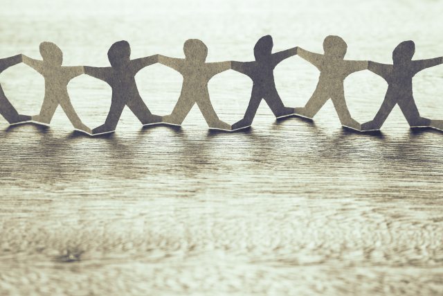 Paper cutout of people holding hands