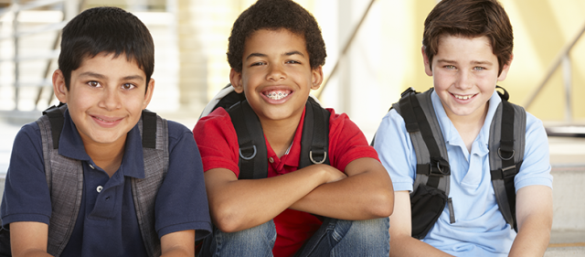 Three smiling boys weasring backpacks