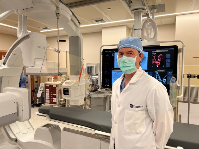 Dr. Wilder standing in an imaging lab with a mask on