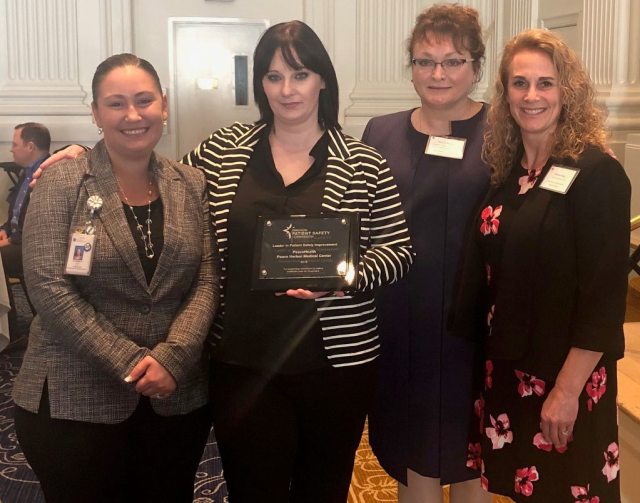 A group of four Peace Harbor PeaceHealth employees accepting an award